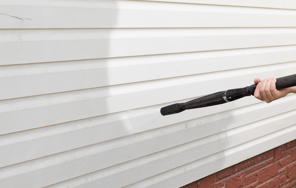 A Gray's House Services crew member power washing vinyl siding in Nashville, TN